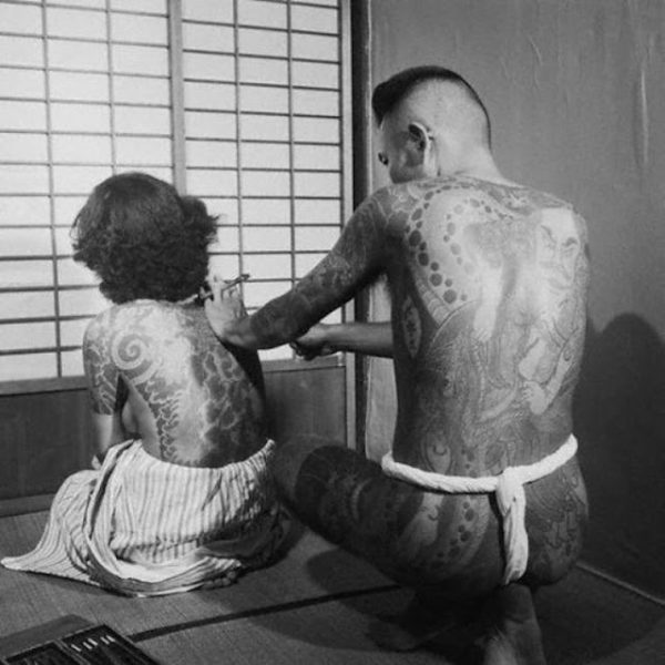 MULHER TENDO AS COSTAS COBERTAS COM TATUAGENS TRADICIONAL JAPONESA CERCA DE 1930